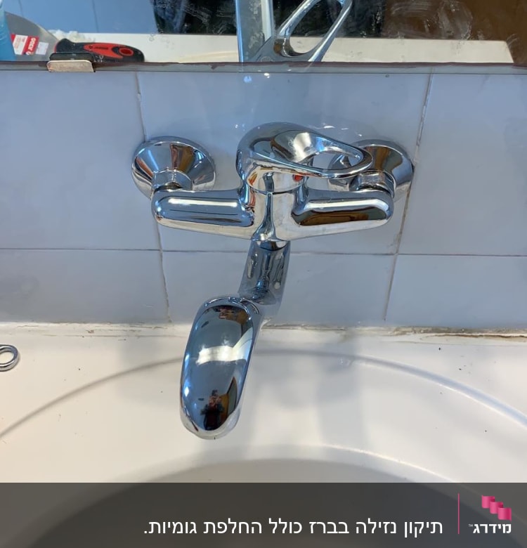 ברז כרום מעל כיור לבן עם מראה